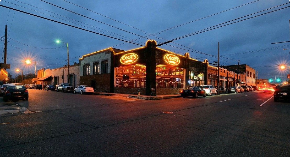 The Cecil's Cajun Kitchen storefront glowing at dusk in downtown DeRidder