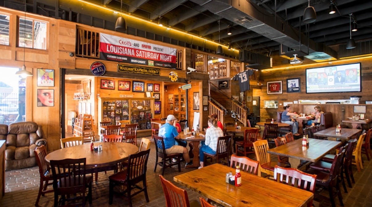 Inside Cecil's — Louisiana Saturday Night banner, sports memorabilia, brick walls